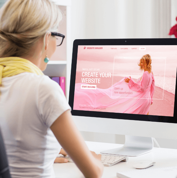 Une femme travaillant sur un ordinateur, explorant une plateforme intuitive de création de site web pour concevoir une présence en ligne moderne et attrayante.